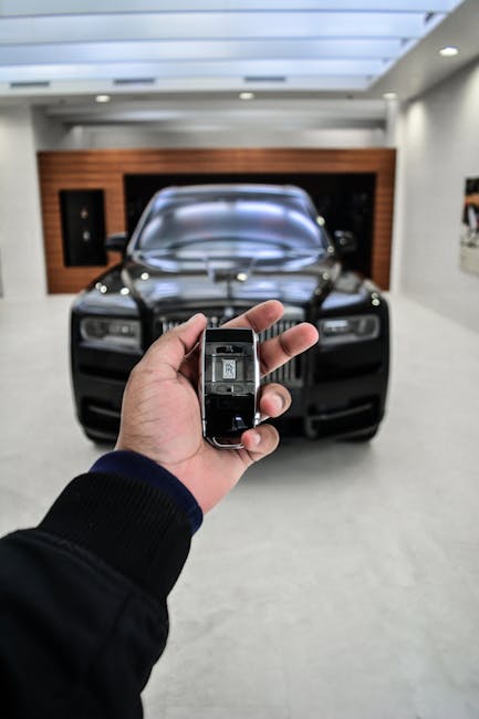 pexels photo 8033684 8033684 Hand holding a luxury car key with sleek vehicle in background. Perfect for transportation themes.